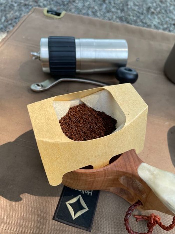 ハンドドリッパーにコーヒー粉をセットする様子。ククサのハンドルが見える