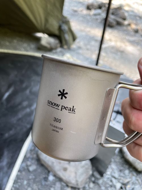 キャンプサイトで手に持ったsnow peakチタンマグ300