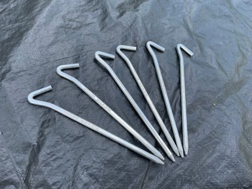 タープの上に並べたUNIFLAMEジュラパワーペグ250。ジュラルミン製の軽量ペグ6本